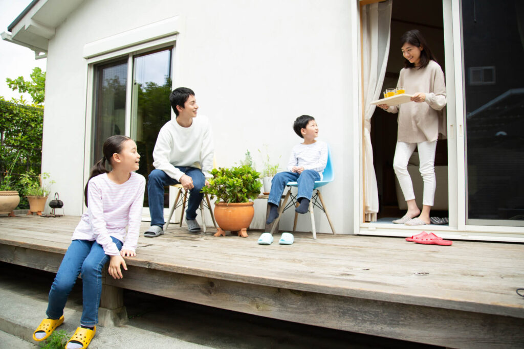 庭のウッドデッキで過ごす家族